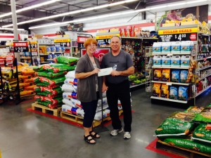 Vicki Cohen, MSGAO director, accepts Bill Becker's winnings at the Tractor Supply Co. in West Memphis.